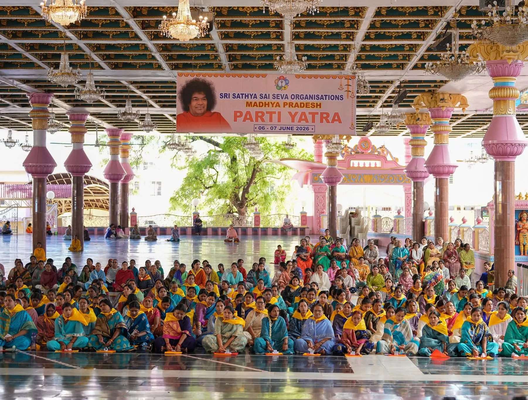 श्री सत्य साई सेवा संगठन मध्य प्रदेश पर्ती यात्रा का बैनर और भक्तगण, जून 2026