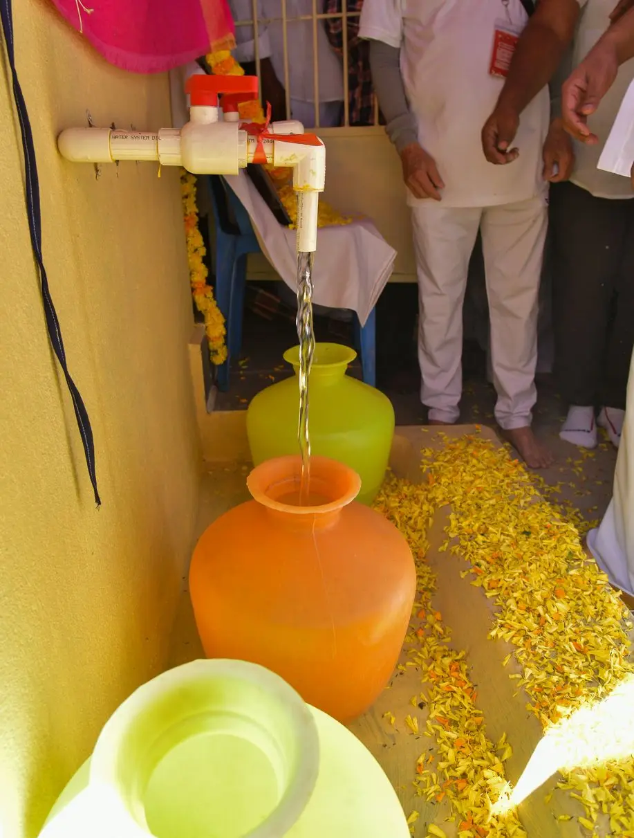 Clean drinking water pouring from a new tap into a clay pot