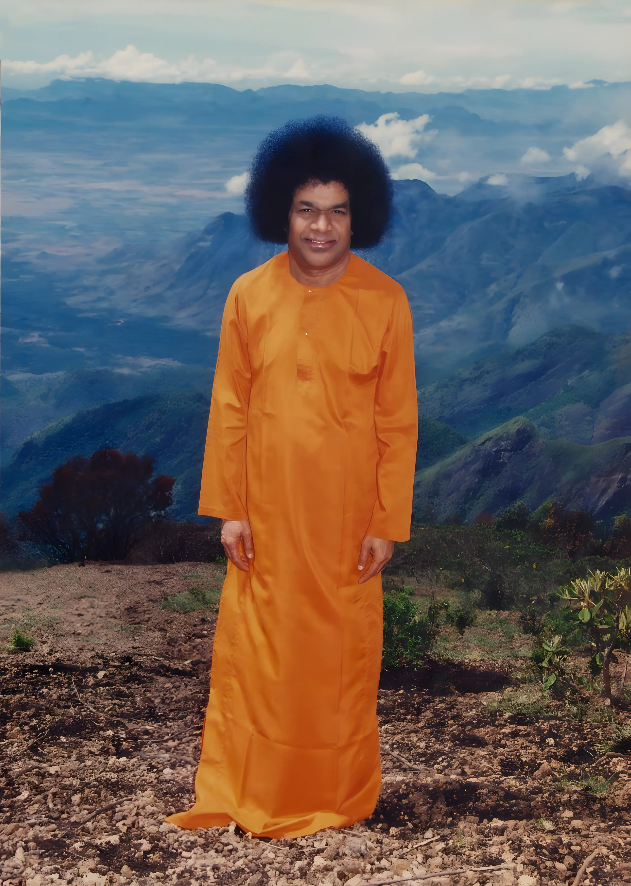 Bhagawan Sri Sathya Sai Baba standing on a mountain ridge