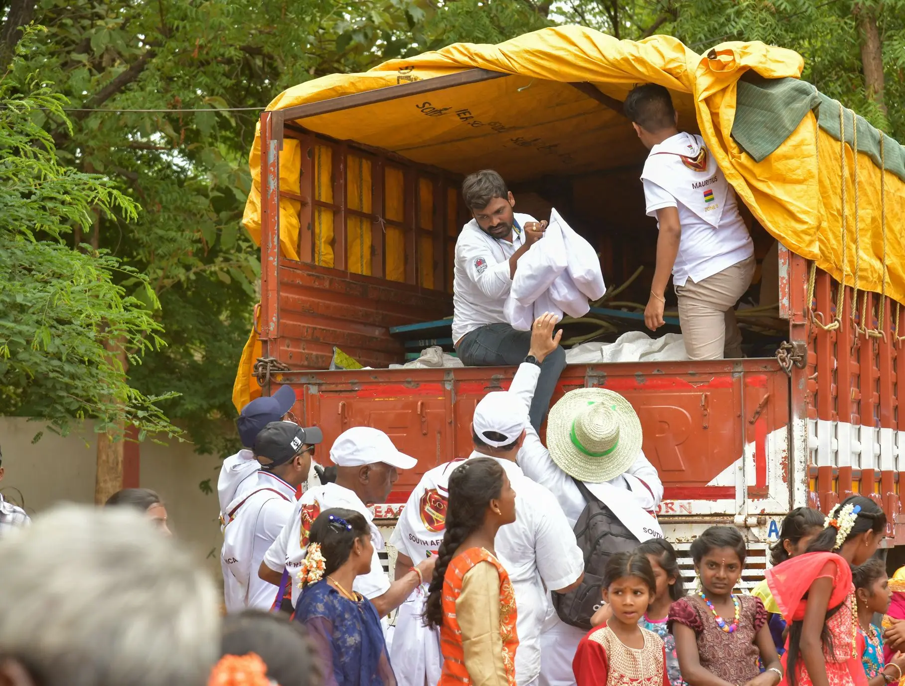 ग्राम सेवा में ग्रामीणों के लिए ट्रक से राहत सामग्री उतारते स्वयंसेवक